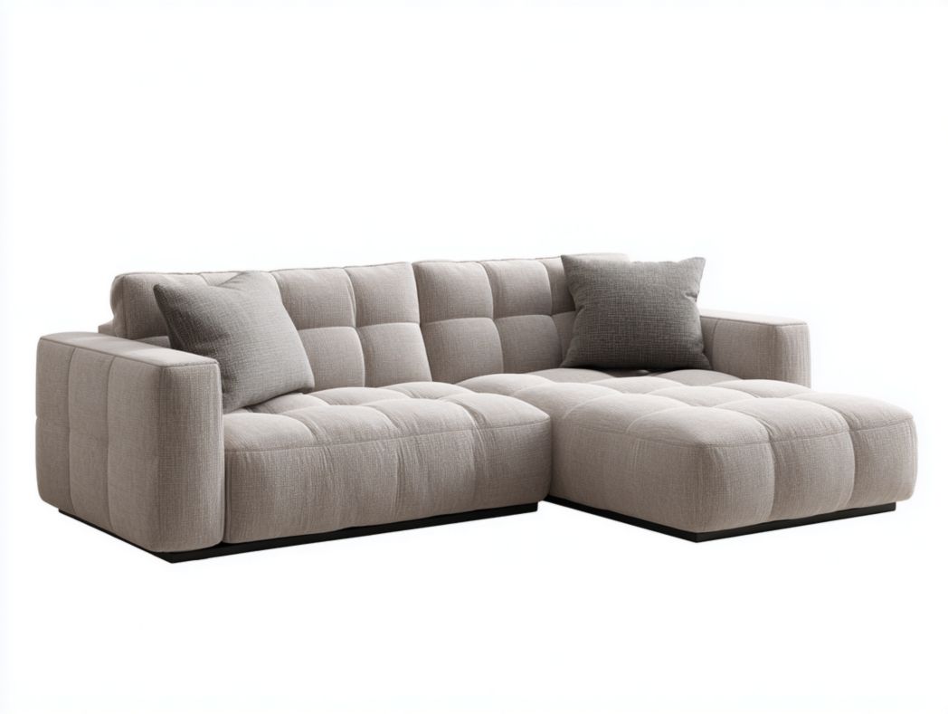 Canapé d’angle en tissu gris clair matelassé avec méridienne à droite et 2 coussins