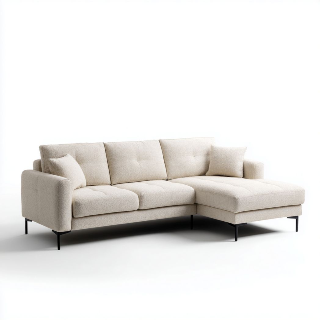 Canapé d'angle en tissu blanc cassé avec une méridienne à droite, pieds noirs et deux coussins