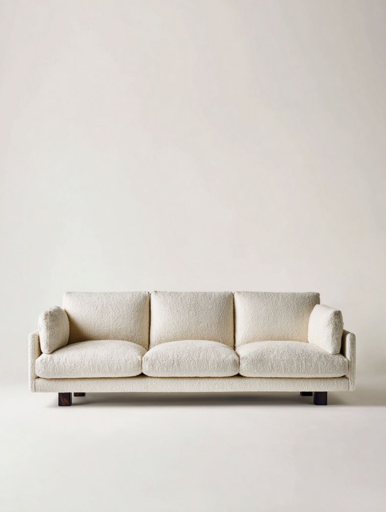 Canapé trois places en tissu blanc cassé avec deux coussins rectangulaires