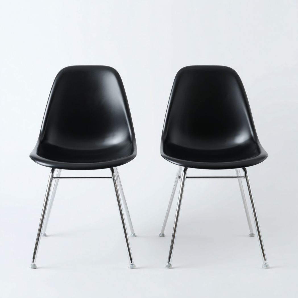 Lot de deux chaises de salle à manger en plastique noir avec pieds métalliques chromés